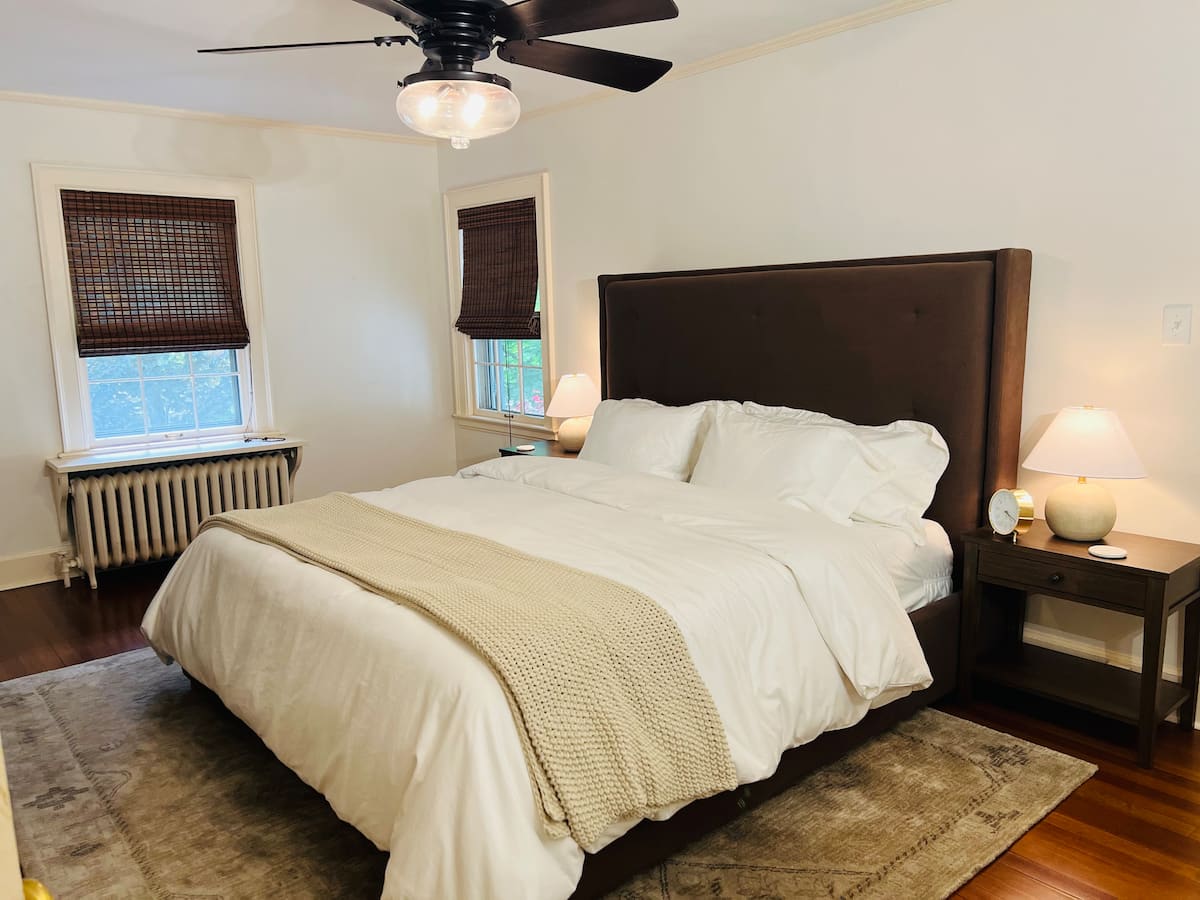 The primary bedroom with a king bed and warm wood furniture